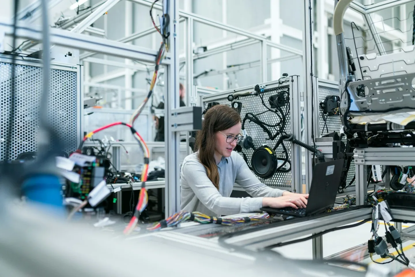 Production coordinator reviewing manufacturing progress on an industrial factory floor