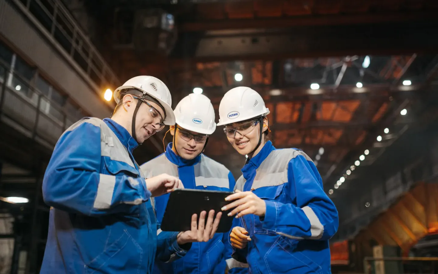 Inspectors reviewing an audit checklist beside industrial machinery inside a manufacturing plant